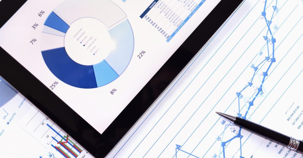 洗濯やお手入れに関する口コミデータをグラフで分析しているイメージ。円グラフや折れ線グラフが表示されたタブレットとレポート用紙の写真。