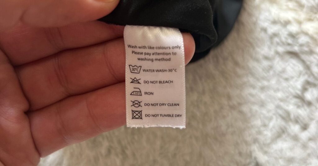 洗濯表示タグを確認してアイロンの可否を確認する手元の写真