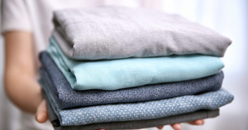 畳まれた日常着がきれいに積まれている写真|ベネクスを普段着やタオルと一緒に洗う場合のイメージ