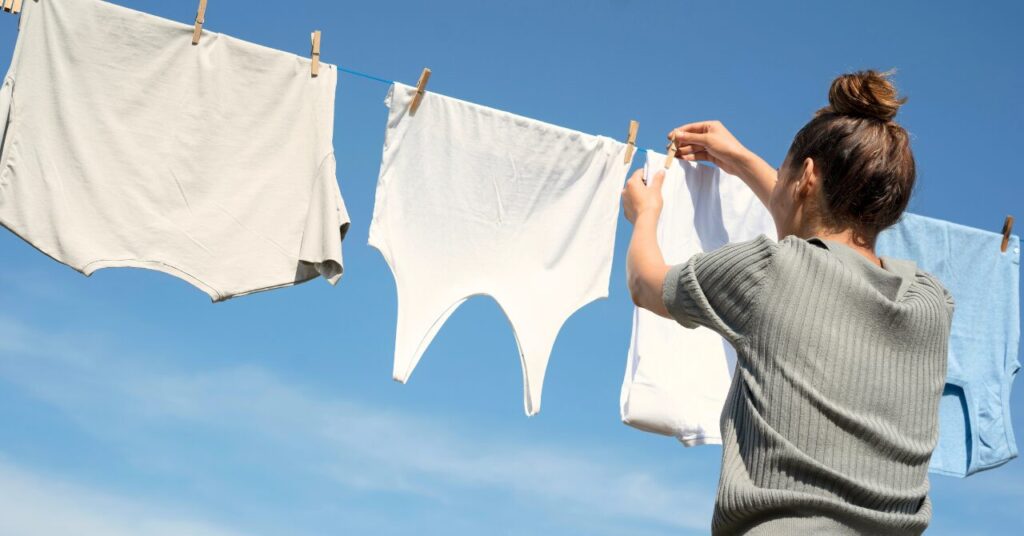 青空の下で洗濯物を干す女性。無理なく続けられるお手入れのイメージ
