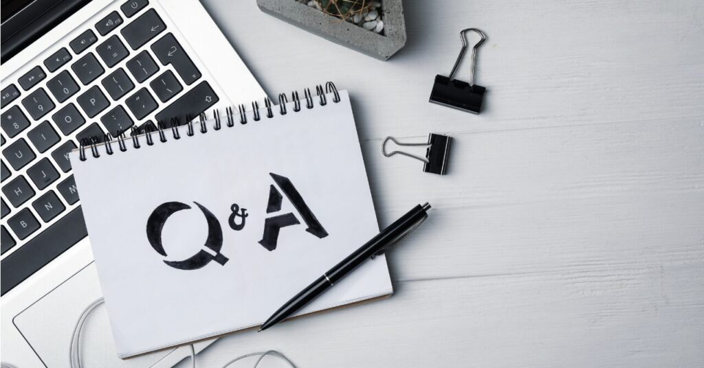 Q&Aと書かれたノートがノートパソコンの横に置かれている写真。リカバリーウェアに関するよくある質問を示すためのイメージ。