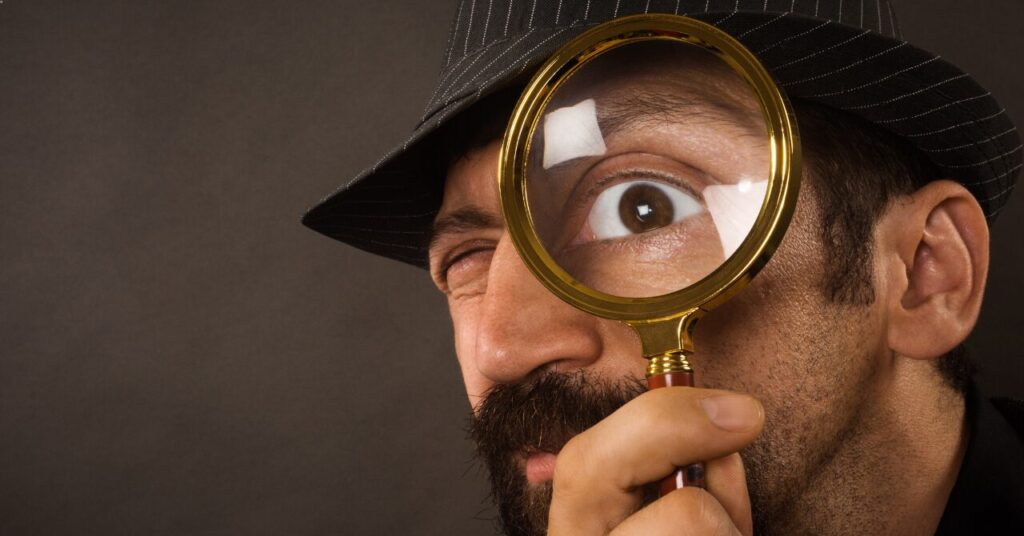 拡大鏡で何かをじっくり観察する男性の写真。リカバリーウェアと普通のパジャマの“生地の仕組み・効果の違い”を細かく比較するイメージ